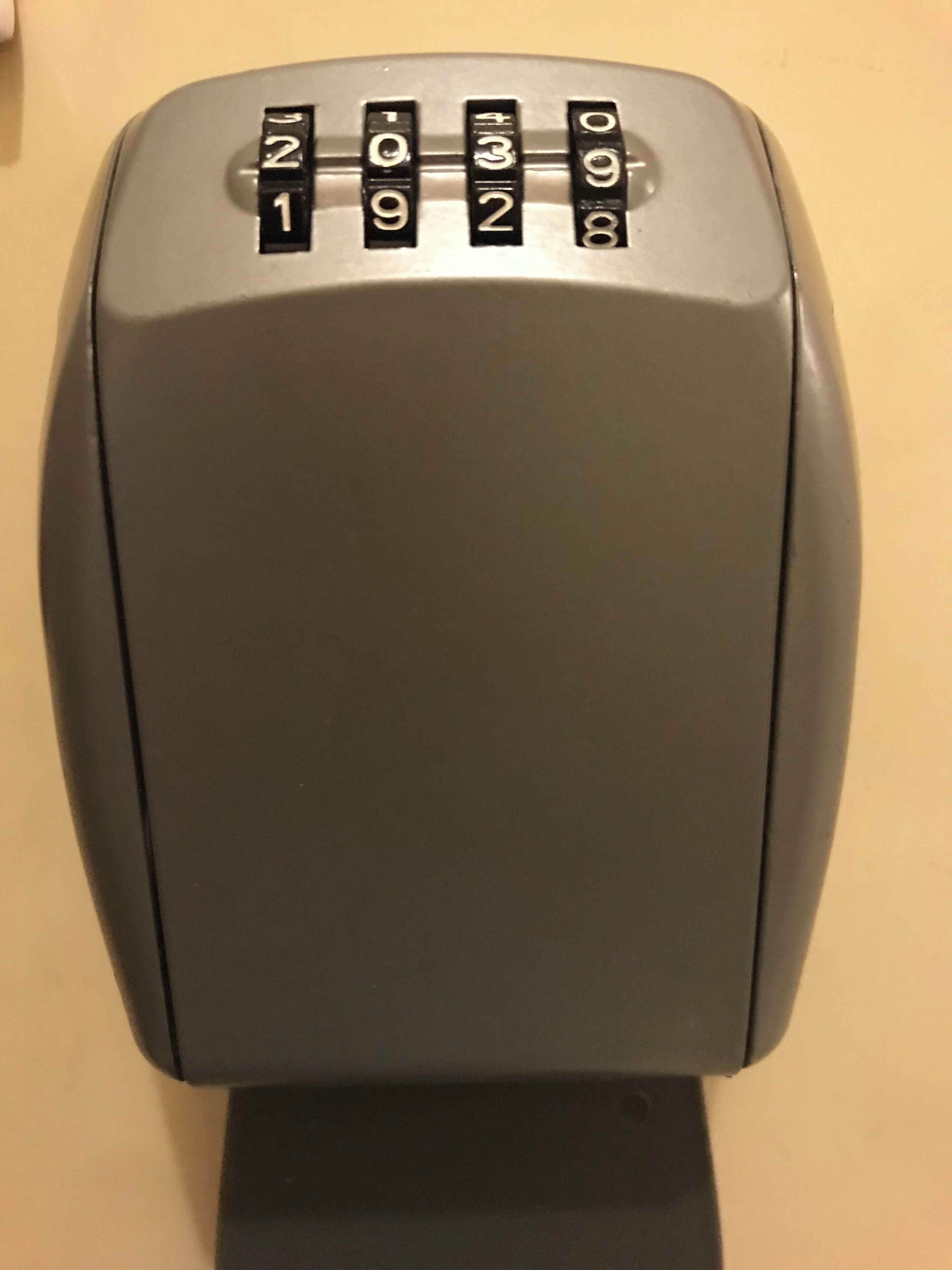 A gray, rectangular object with a keypad featuring numbers 1 through 9 and 0.
