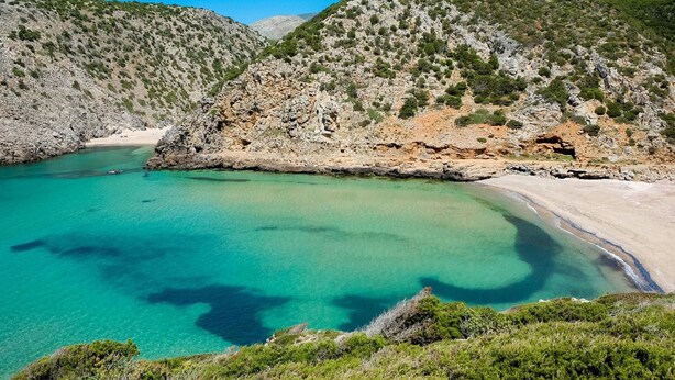 A coastal landscape with clear turquoise waters, rocky cliffs, and sparse vegetation. - Room in Guest Room - S'olivariu Village Affittacamere - King Room With Roll-in Shower (Piscinas)
