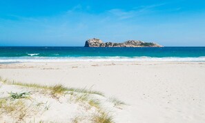 A beach with white sand and a rocky outcrop in the background. - Room in Guest Room - S'olivariu Village Affittacamere - Junior Suite Terrace (Piscinas)