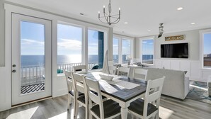 Un comedor con vista al océano, un candelabro y un letrero que dice 'OAK ISLAND'.