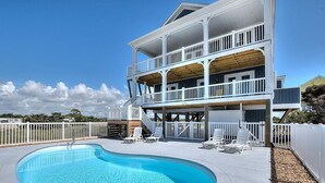 A two-story house with a swimming pool and outdoor seating. - Experience luxury at 'Gratitude' in Oak Island, a spacious 5-bedroom ocean-view retreat. (Oak Island)