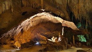 Una cueva con una gran formación rocosa iluminada.