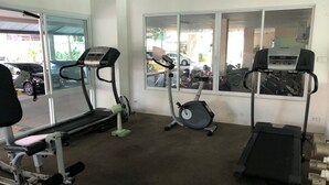 A gym with treadmills, an elliptical, and weight machines. - Platinum Suites Floor 6 Room 63 (Pattaya)