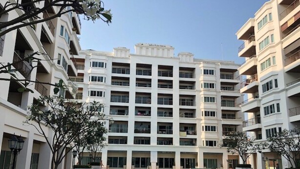 A modern multi-story building with a central courtyard featuring a swimming pool. - Platinum Suites Floor 6 Room 63 (Pattaya)