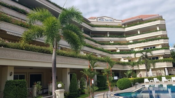 A multi-story hotel with a pool area, palm trees, and a sign reading "Nordic Park Hill". - Nordic Park Hill Residence Flat (Pattaya)
