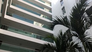 A multi-story building with a modern architectural design, featuring balconies and large windows.