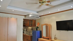 A compact kitchen with wooden cabinets, a blue refrigerator, and a built-in microwave. - Jomtien Beach Condominium A2 F13 R4 (Pattaya)