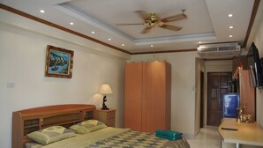 A bedroom with a bed, a wardrobe, a desk, and a ceiling fan. - Jomtien Beach Condomijium Jbc S1 F4 R25 (Pattaya)