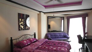 A bedroom with a bed, a desk, a chair, a ceiling fan, and a large window with curtains. - Jomtien Beach Condominium Jbc A2 F4 R28 (Pattaya)