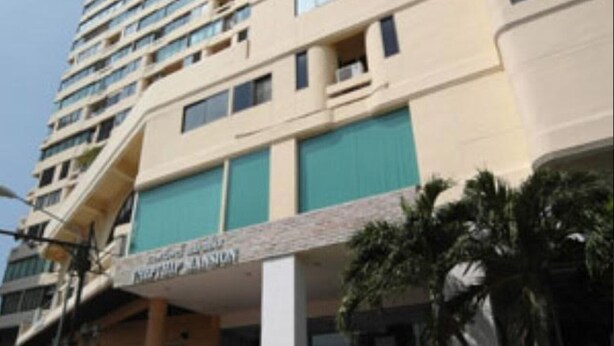Un hôtel à plusieurs étages, doté d’une entrée imposante et d’une enseigne indiquant « Hôtel de luxe ».