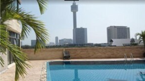 Une piscine offrant une vue sur une haute tour et les bâtiments environnants.