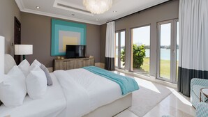 A modern bedroom with a large bed, a television, and a view of the outdoors. - Maison Privee - Palm Jumeirah Beach Front XL Villa w/Prvt Pool (Dubai)