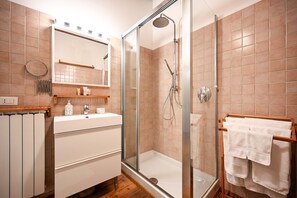 A modern bathroom with a glass-enclosed shower, a white sink, and a towel rack. - Venice apartment with breath-taking Grand Canal view (Venecia)