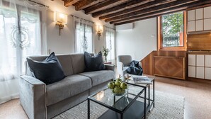 Una sala de estar acogedora con un sofá gris, una mesita de centro con un cuenco de manzanas y un techo de madera.