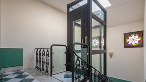 Una escalera con barandillas de vidrio y suelo de mármol a cuadros.