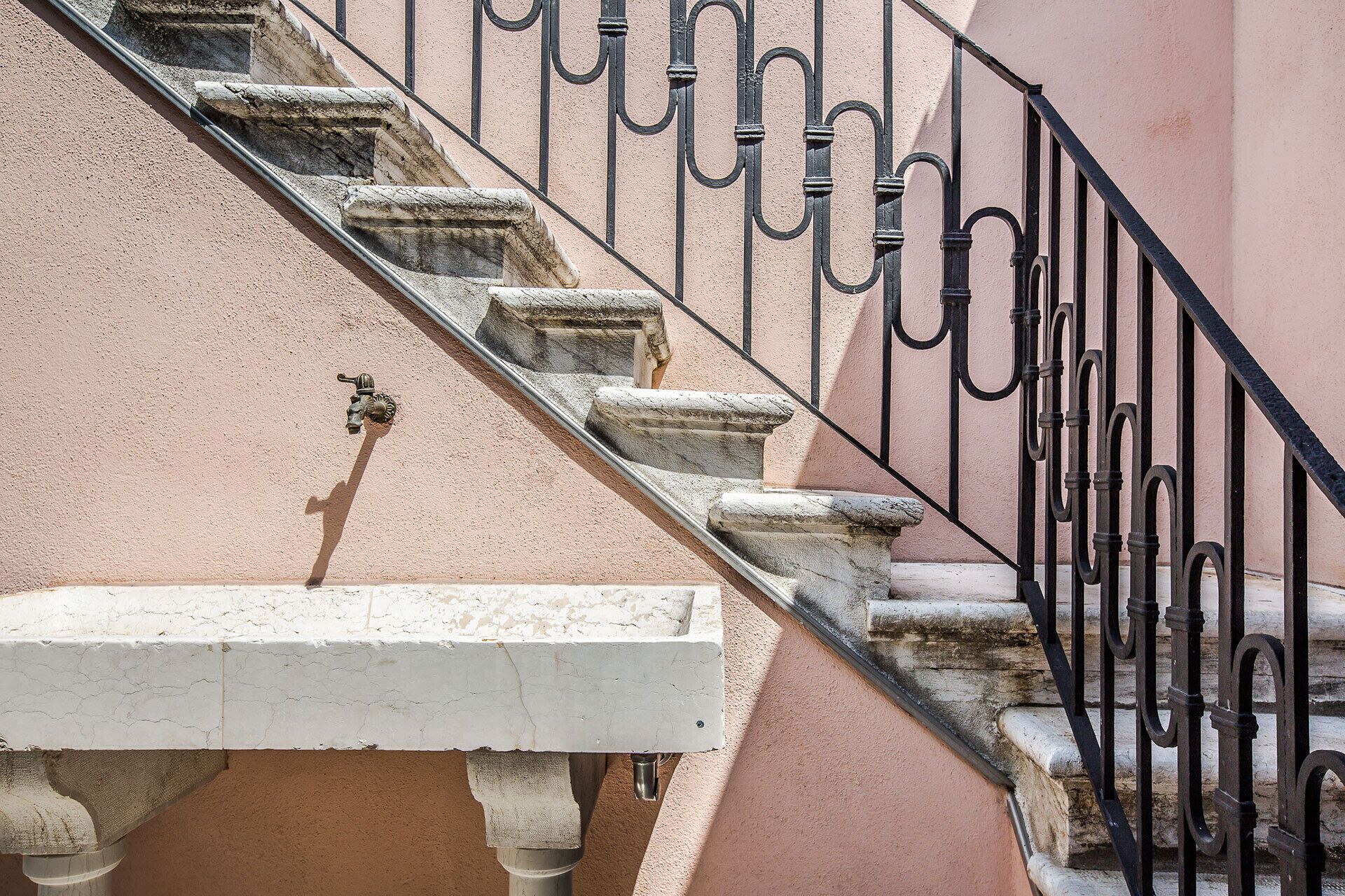 A staircase with stone steps and a metal railing.