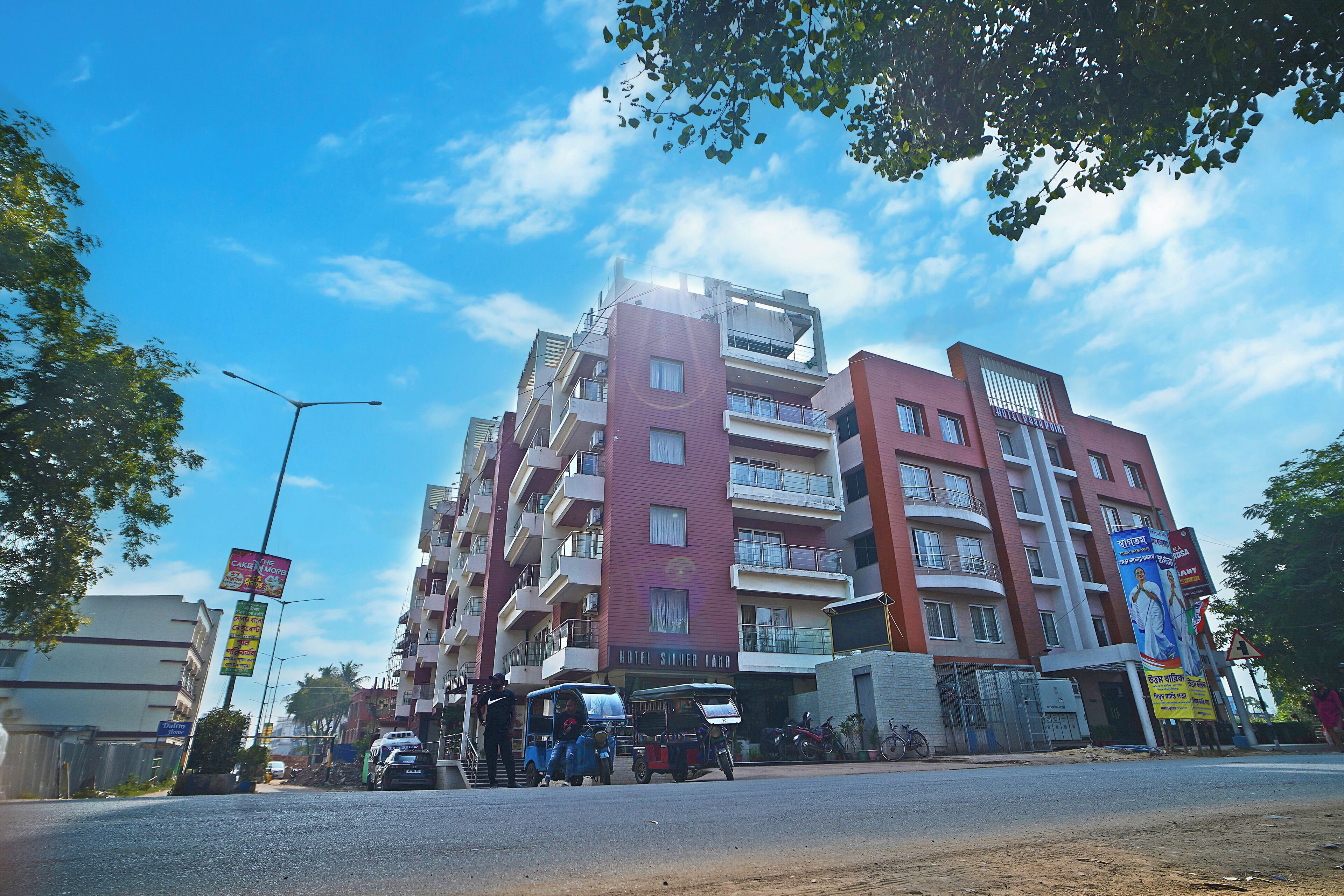 A multi-story hotel with balconies, a prominent entrance, and a clear sky.