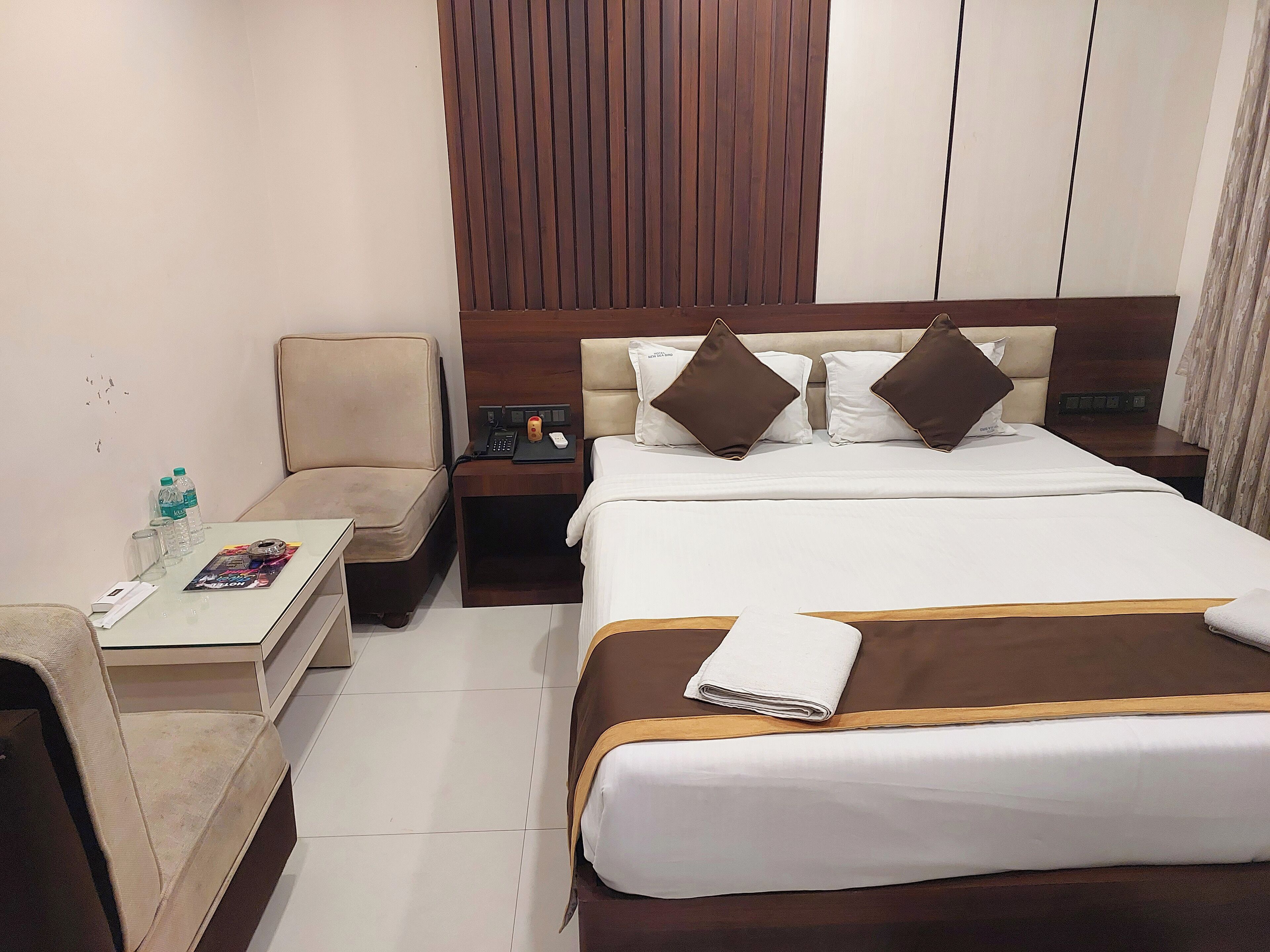 Une chambre d’hôtel avec un lit, un canapé, une petite table et une table de chevet.