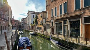 Un canal étroit, bordé de bâtiments historiques dotés de balcons et de fenêtres donnant sur l’eau.
