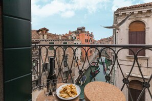 A balcony with a table, a plate of chips, and two glasses.