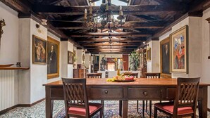 A dining room with a wooden table, chairs, and a chandelier. - Unconventional Loft Style Apartment in San Barnaba (Venecia)