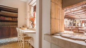 A kitchen with a stone countertop, a wooden bookshelf, and a dining area with chairs. - Unconventional Loft Style Apartment in San Barnaba (Venecia)