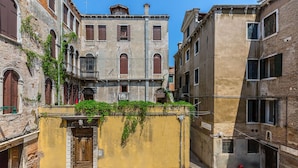 A narrow street with historic buildings, a yellow wall with a door, and a red fire hydrant. - Spacious and Charming Apartment Near Fenice Theatre (Venecia)