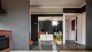 A modern kitchen with dark walls, a white cabinet, and a hanging light fixture. - Quiet and Eclectic Apartment next to the Fenice Theatre (Venecia)