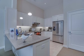 A modern kitchen with white cabinets, stainless steel appliances, and a granite countertop. - 2 Bedroom Apartment located in Washington Dcâs Penn Quarter. 2 Apts by RedAwning (Washington)