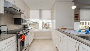 A modern kitchen with a built-in oven, microwave, and stainless steel range hood.