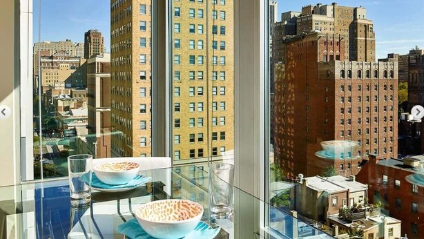 A high-rise building with a view of other buildings and a glass table with a bowl and glass. - Philly 2br Fully Furnished Apartment 2 Bedroom Apts by RedAwning (Philadelphia)