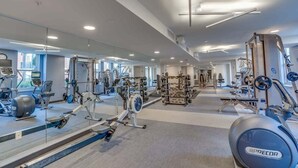 Academia moderna com diversos equipamentos de exercício, espelhos amplos e um espaço amplo.