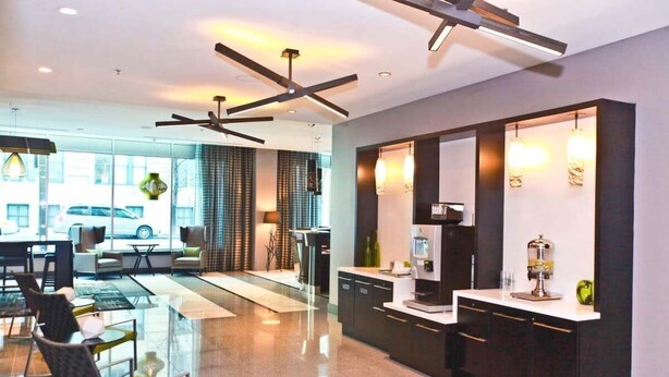 A modern hotel lobby with a seating area, a counter, and a kitchen area. - 2br Furnished Apartment In Baltimore Downtown 2 Bedroom Apts by RedAwning (Baltimore)