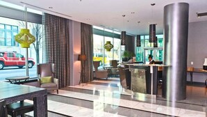 A modern hotel lobby with a reception desk, seating area, and large windows. - 2br Furnished Apartment In Baltimore Downtown 2 Bedroom Apts by RedAwning (Baltimore)