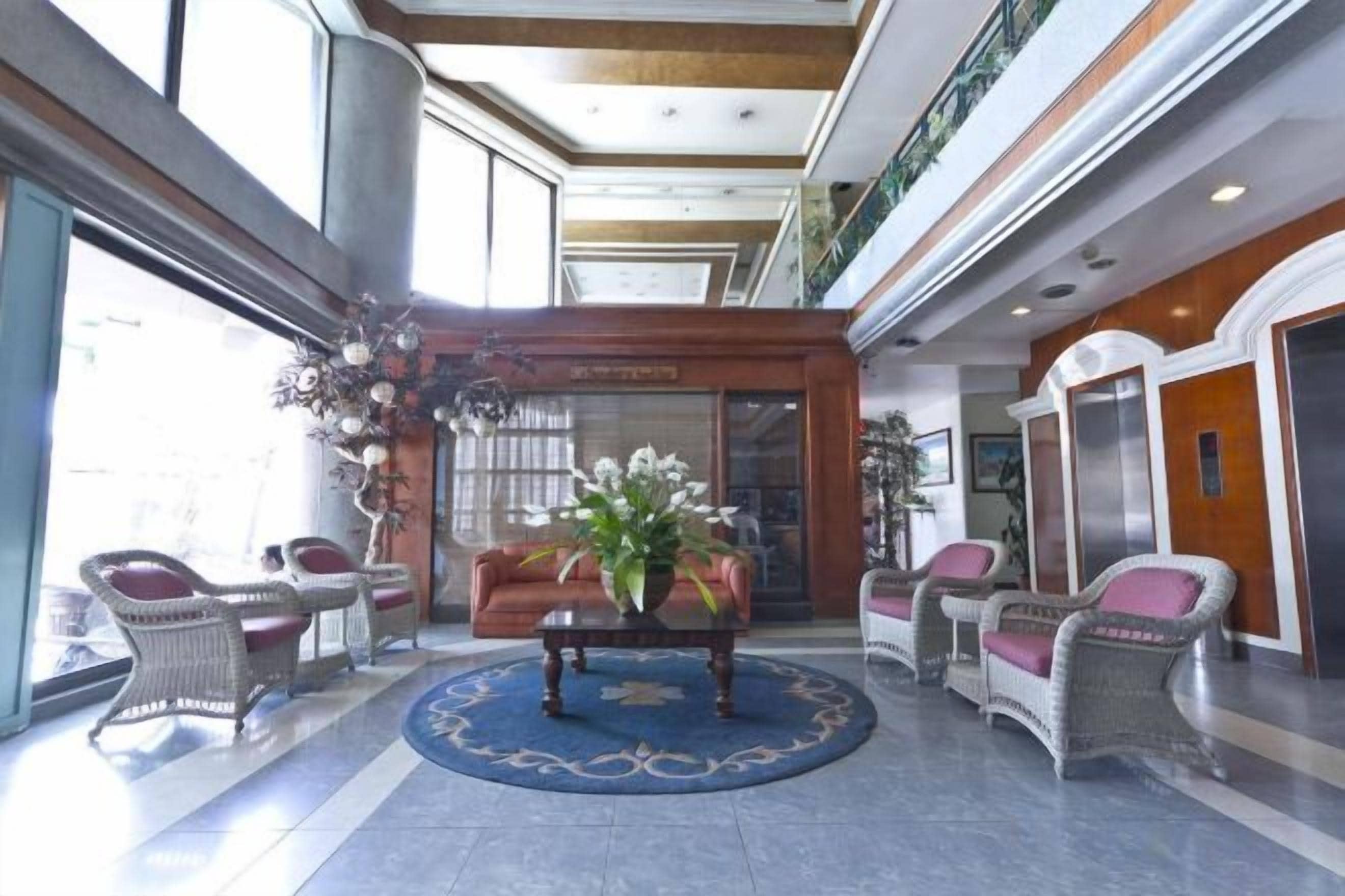 Un vestíbulo con mostrador de recepción, zona de estar y un gran ventanal.