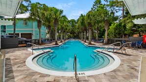 A swimming pool with a 3 FT depth marker, surrounded by lounge chairs and palm trees, with a building in the background. - Close to Dining & Shopping, 1-Floor Cottage, Pool + Free Attraction Tickets! (Santa Rosa Beach)