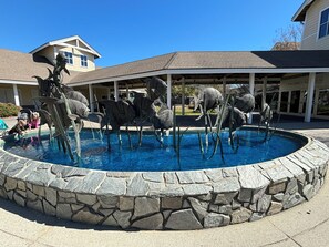 Ein Schwimmbecken mit Steinrand und einer Fischskulptur.