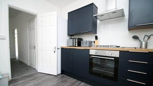 A modern kitchen with dark cabinets, a built-in oven, and a toaster.