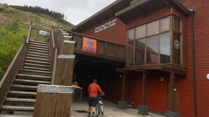 A wooden staircase leading to a building with a sign for 'Glynncarrying Ponds and Mountain Bike Centre'.