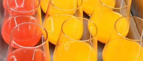 Varios vasos transparentes llenos de jugo de naranja.