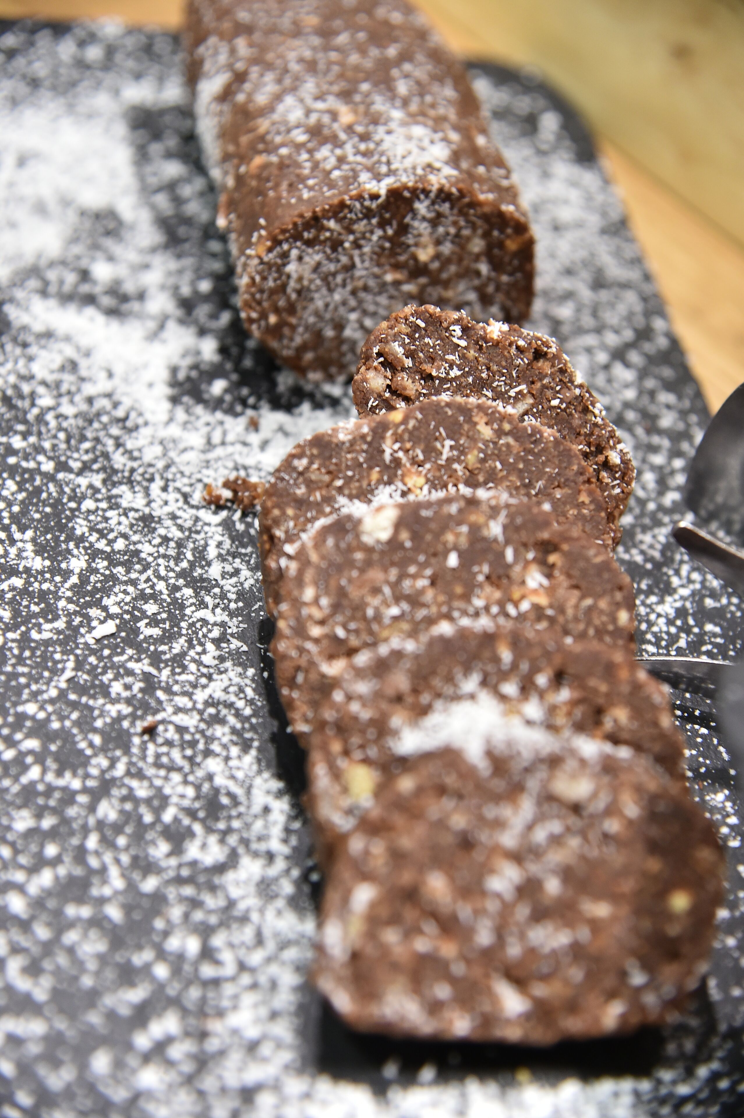 A chocolate dessert with powdered sugar on a slate surface.