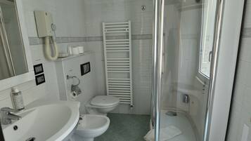 Ein Badezimmer mit Duschkabine, Toilette und Waschbecken.