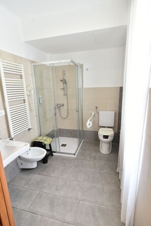 A modern bathroom with a glass-enclosed shower, a toilet, and a sink. - Hotel Okinawa (Rimini)