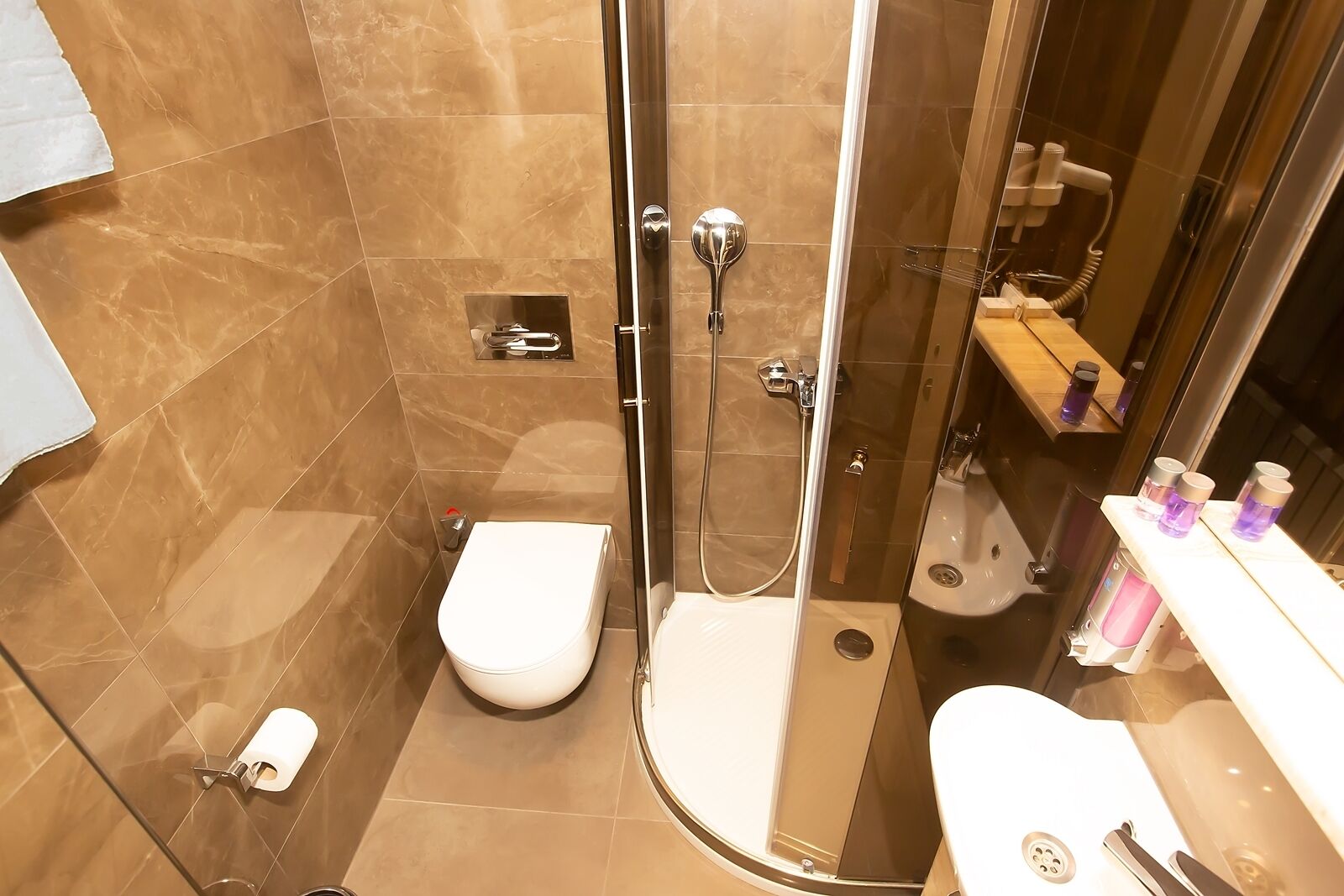 Un baño moderno con ducha de vidrio, inodoro y lavabo con tocador.