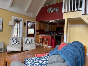 A living room with a sofa, ottoman, and a dining table.