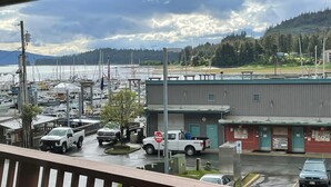 Uma marina com barcos, um caminhão e um edifício com telhado verde.