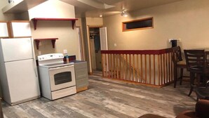 Cocina compacta con refrigerador, estufa y mostrador de madera.