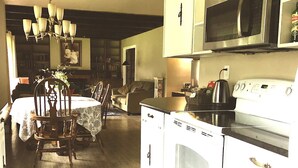 Uma cozinha com área de jantar, piso de madeira e um lustre.