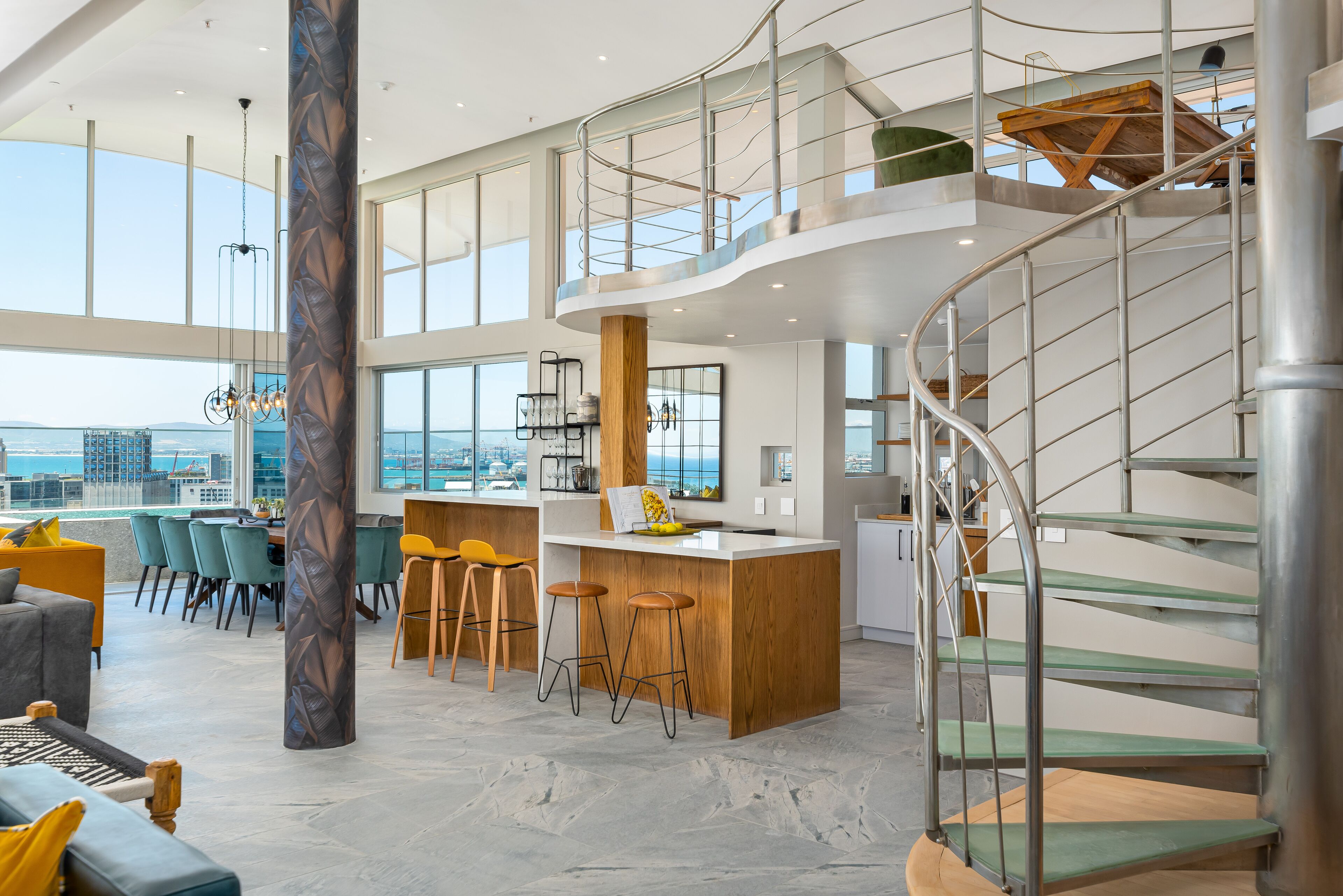 Un interior moderno con una barra central tipo isla, techos altos y una escalera de caracol.