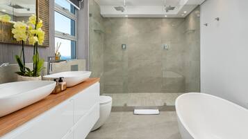 Luxe penthouse | Badkamer | Een douche, een haardroger, handdoeken, zeep